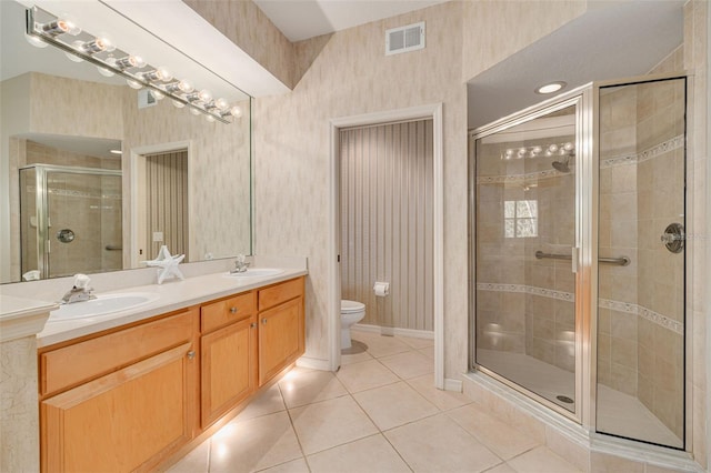 bathroom featuring wallpapered walls, a shower stall, a sink, and tile patterned floors