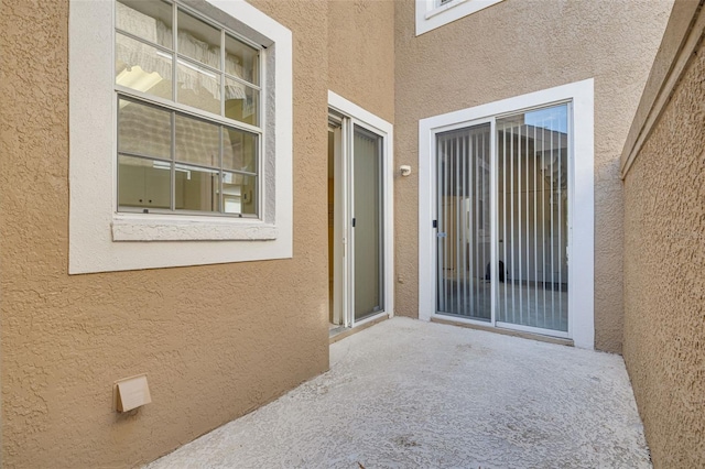 property entrance featuring a patio and stucco siding