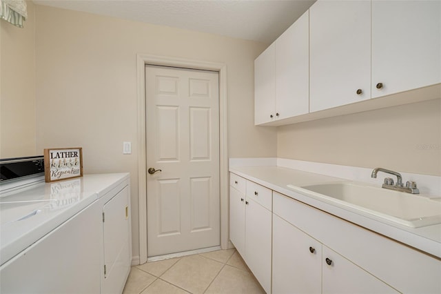 laundry room featuring washer and dryer, cabinet space, a sink, and light tile patterned flooring