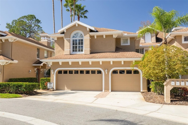 view of front of home featuring driveway, a shingled roof, and stucco siding