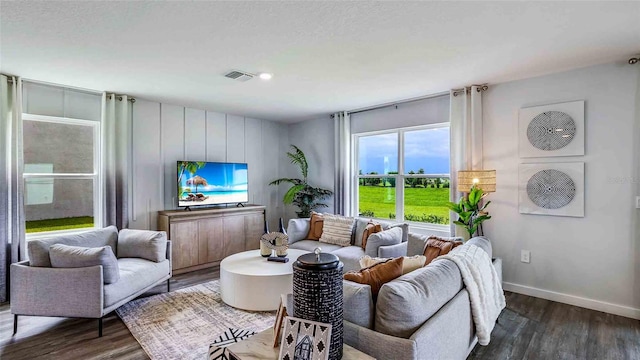 living room with visible vents, baseboards, and dark wood-style flooring