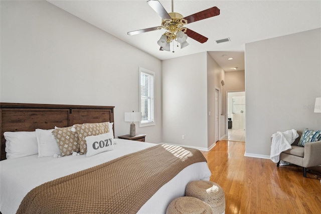 bedroom featuring ceiling fan, wood finished floors, visible vents, and baseboards