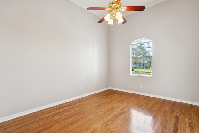 spare room featuring ornamental molding, ceiling fan, baseboards, and wood finished floors