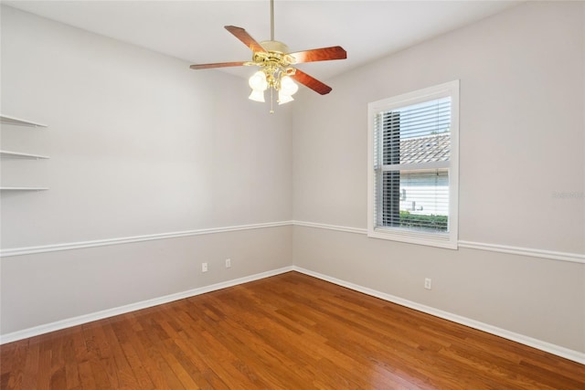 spare room with ceiling fan, baseboards, and wood finished floors