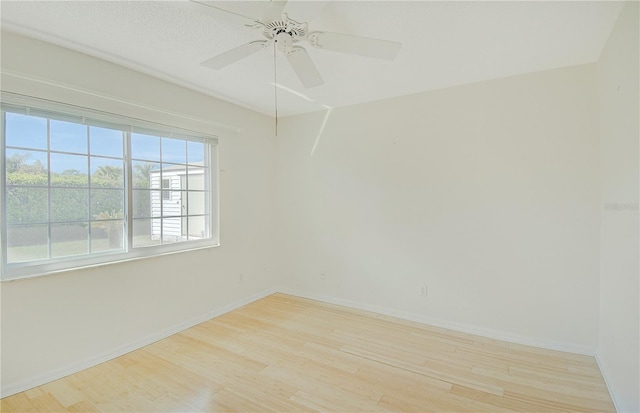 unfurnished room with a ceiling fan, wood finished floors, and baseboards