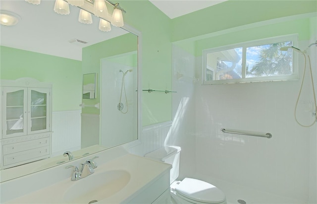 full bath with visible vents, toilet, wainscoting, a shower, and vanity