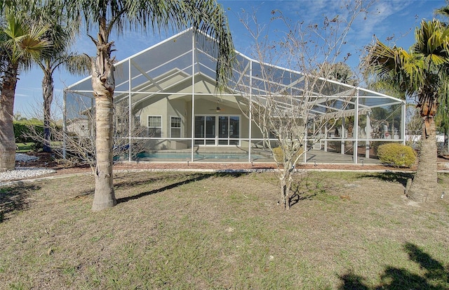 back of property with an outdoor pool, stucco siding, ceiling fan, a lanai, and a patio area