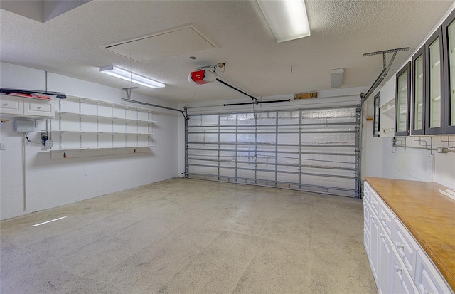 garage with a garage door opener and concrete block wall