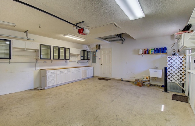 garage featuring electric panel, a garage door opener, and concrete block wall