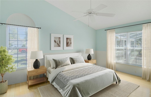 bedroom with lofted ceiling, light wood-style floors, and ceiling fan