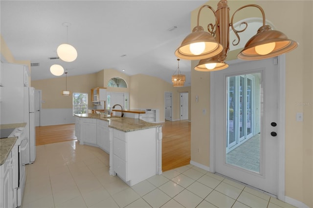 10302 Belltower St, Spring Hill, FL 34608 - kitchen featuring a sink, vaulted ceiling, light tile patterned floors, white cabinetry, and decorative light fixtures