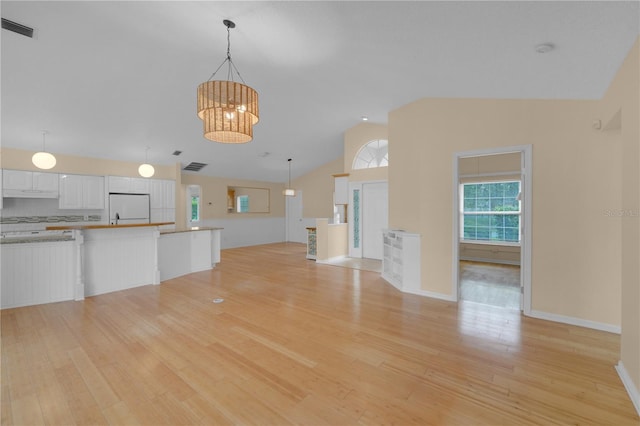 10302 Belltower St, Spring Hill, FL 34608 - unfurnished living room with vaulted ceiling, light wood finished floors, a chandelier, and baseboards