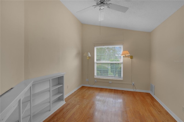 10302 Belltower St, Spring Hill, FL 34608 - empty room with wood finished floors, vaulted ceiling, ceiling fan, baseboards, and a textured ceiling