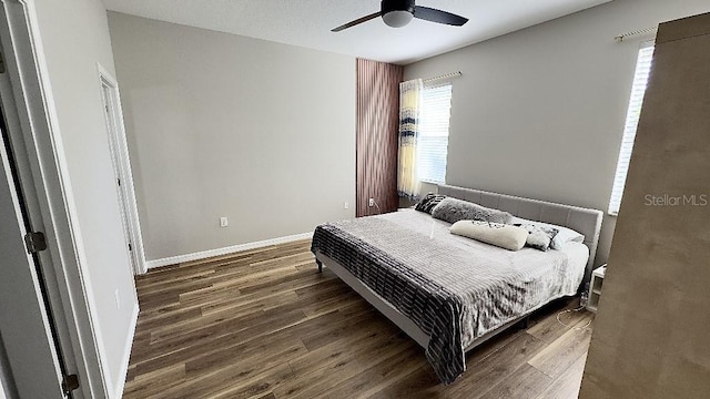 bedroom featuring ceiling fan, baseboards, and wood finished floors