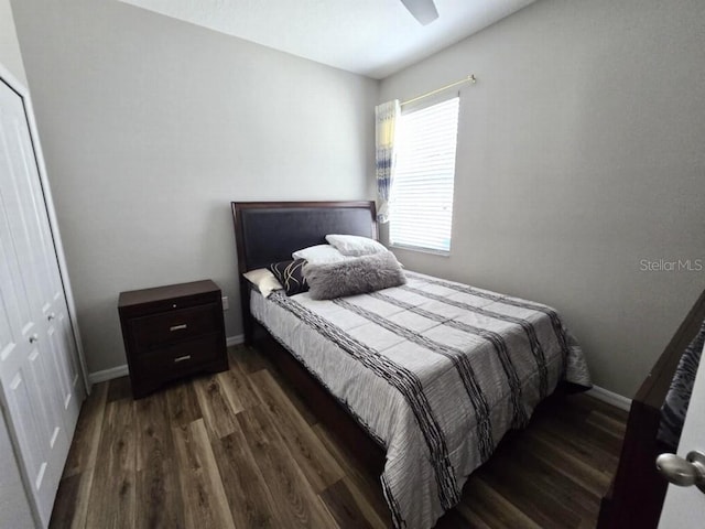 bedroom with a ceiling fan, wood finished floors, a closet, and baseboards