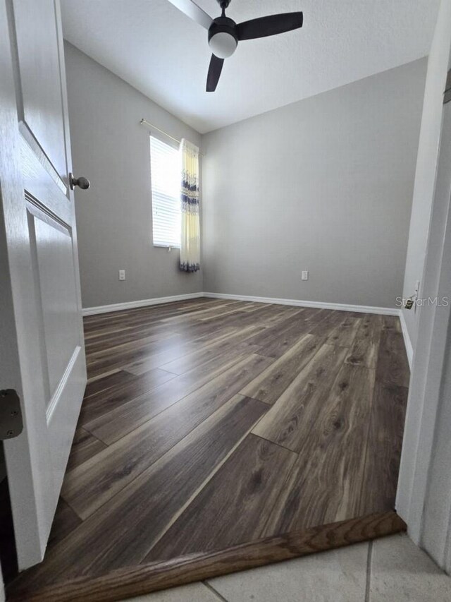 unfurnished bedroom with ceiling fan, baseboards, and wood finished floors