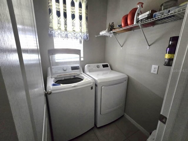 washroom featuring washer and dryer, laundry area, light tile patterned flooring, and baseboards