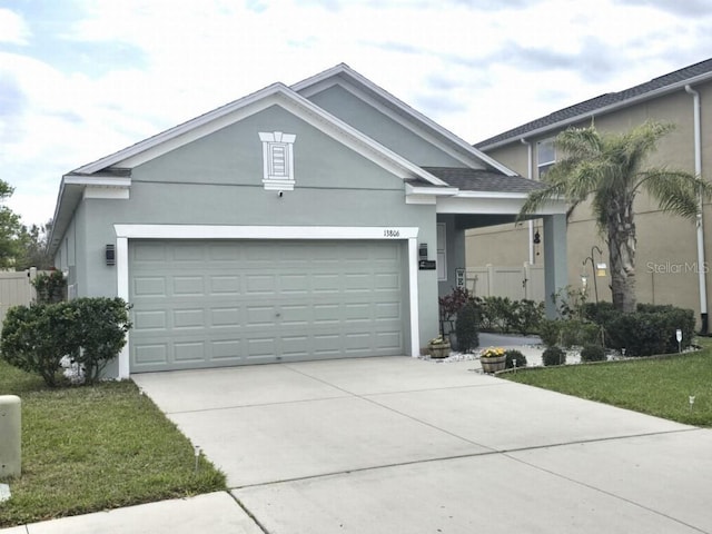 single story home with concrete driveway, a front lawn, a garage, and stucco siding