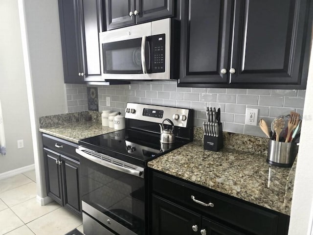 kitchen featuring backsplash, appliances with stainless steel finishes, and dark cabinetry