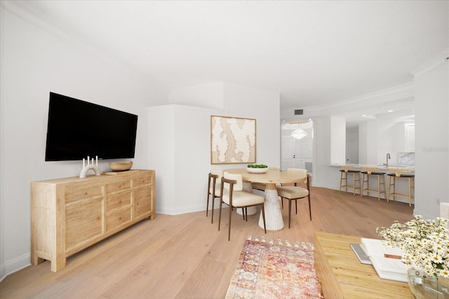 dining space with visible vents, light wood-style flooring, and baseboards