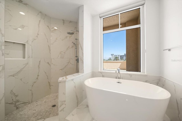 bathroom featuring tile walls, a soaking tub, marble finish floor, and a marble finish shower