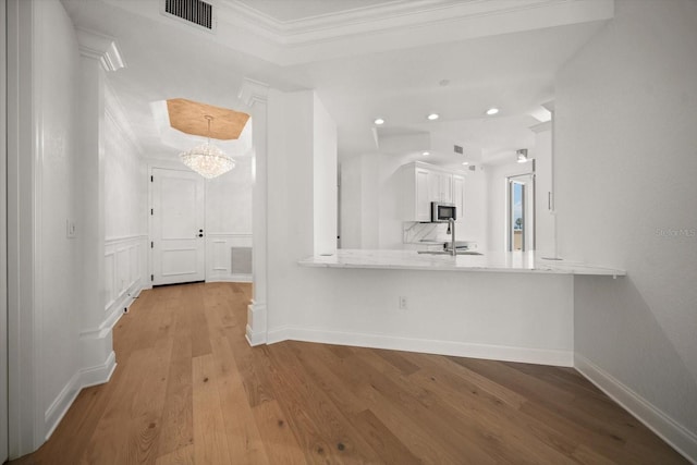 interior space with light wood-style flooring, recessed lighting, visible vents, baseboards, and ornamental molding