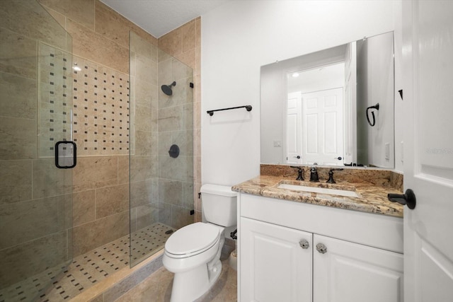 bathroom with a shower stall, toilet, and vanity