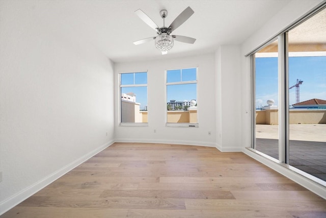 unfurnished room featuring light wood-type flooring, ceiling fan, and baseboards