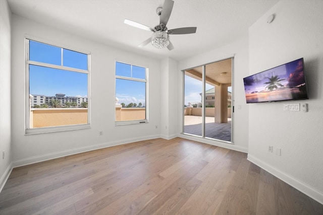 empty room featuring a ceiling fan, baseboards, and wood finished floors