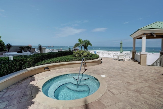 view of pool with a water view, a patio area, and a gazebo