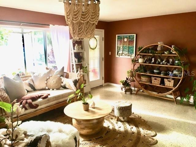 living area featuring an inviting chandelier and baseboards