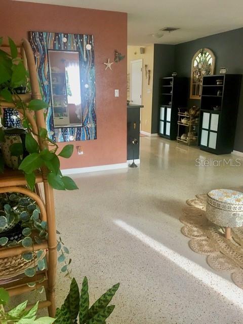 interior space featuring visible vents, baseboards, and speckled floor