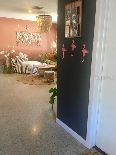 interior space with baseboards, visible vents, and speckled floor