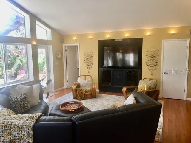 living room with light wood finished floors and vaulted ceiling