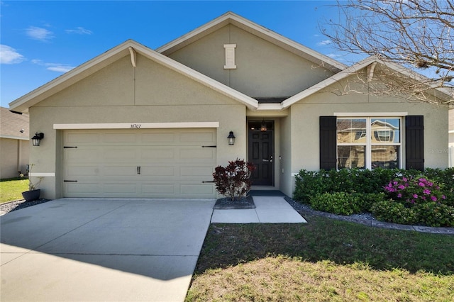 view of front of house featuring a garage, driveway, and stucco siding