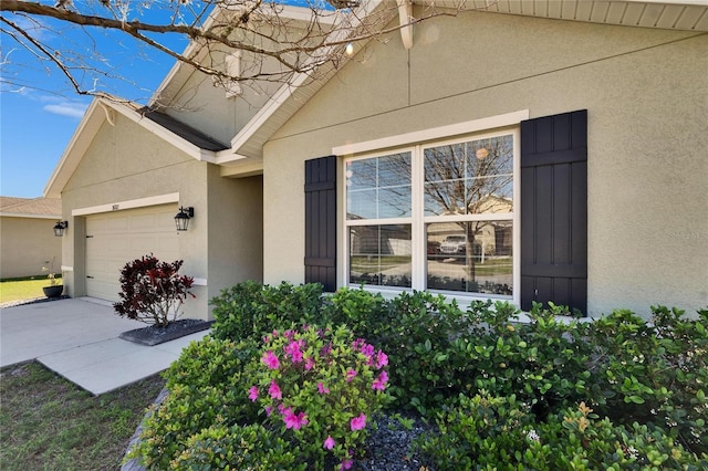 property entrance featuring an attached garage and stucco siding