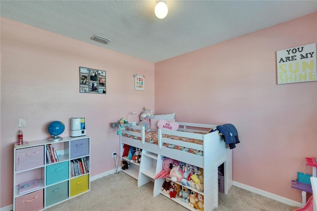 bedroom featuring a textured ceiling, carpet flooring, visible vents, and baseboards