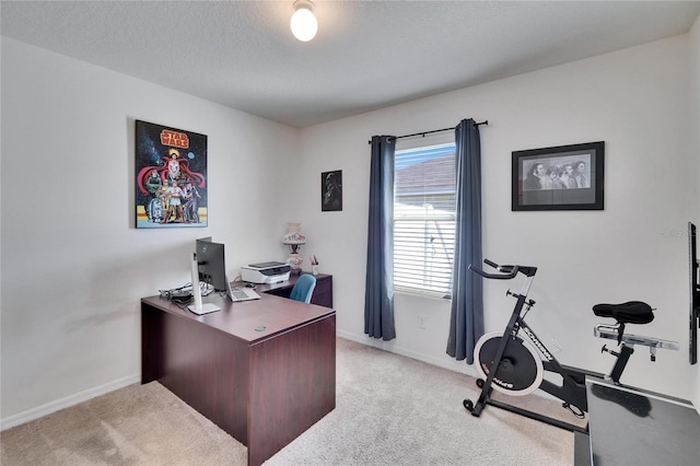 office space with light carpet, a textured ceiling, and baseboards