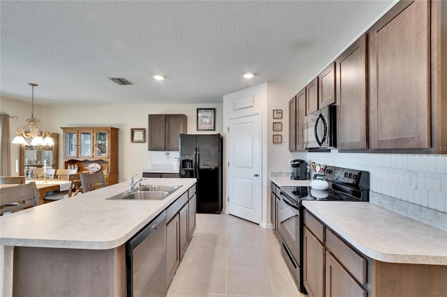 kitchen with light countertops, visible vents, backsplash, a sink, and black appliances