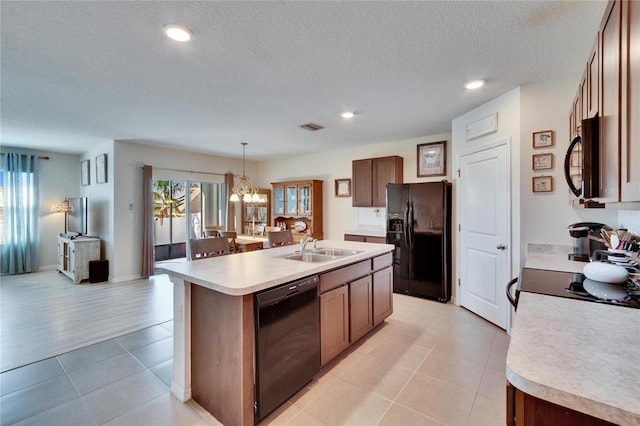 kitchen featuring light countertops, visible vents, a sink, and black appliances