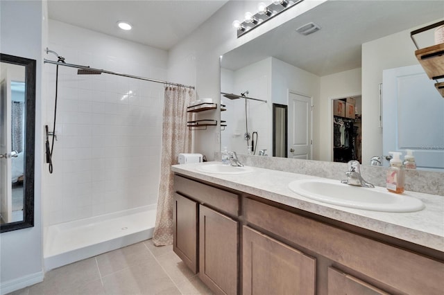 bathroom with a stall shower, tile patterned flooring, a sink, and visible vents