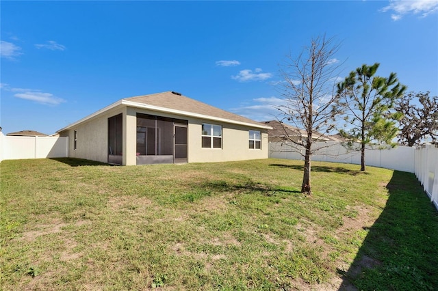 rear view of property with a yard, a fenced backyard, a sunroom, and stucco siding