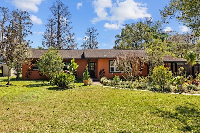 ranch-style house with a front yard and stucco siding