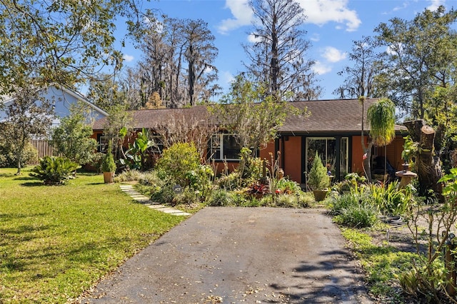 single story home with roof with shingles and a front yard