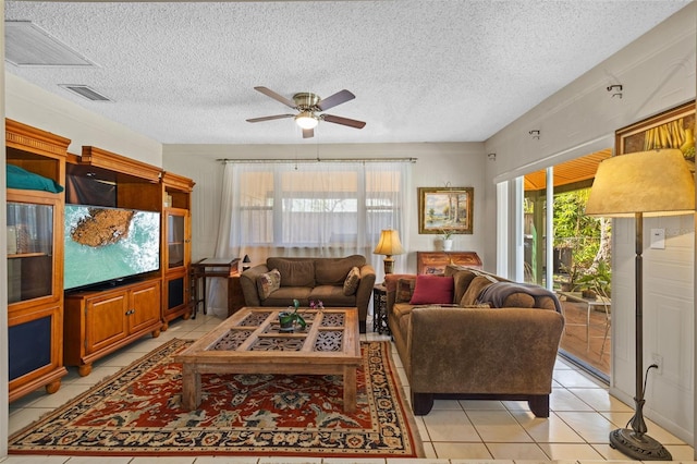 living room with light tile patterned floors, ceiling fan, a textured ceiling, and visible vents