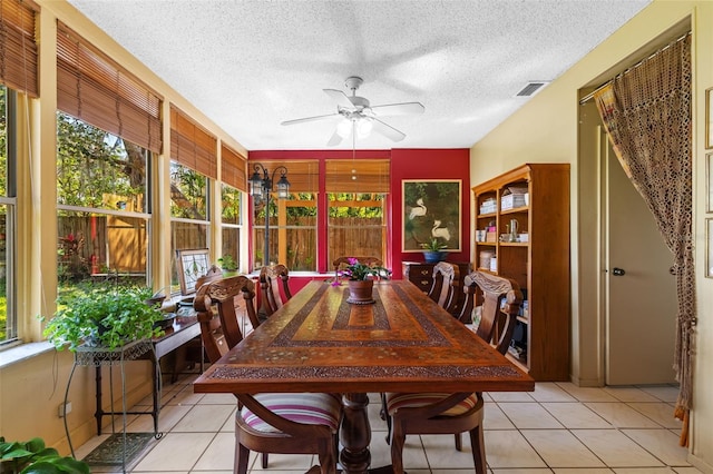 dining room featuring a healthy amount of sunlight, light tile patterned floors, visible vents, and a ceiling fan