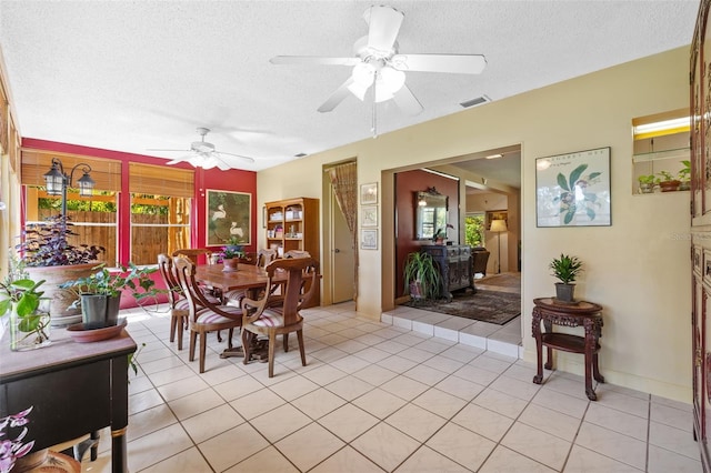 dining space with light tile patterned floors, ceiling fan, visible vents, and a textured ceiling