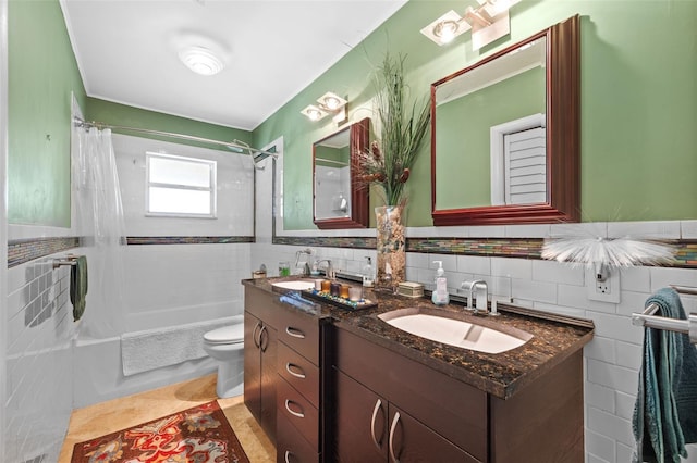 full bathroom with toilet, a sink, and tile walls