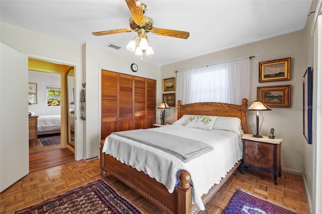 bedroom with ceiling fan, a closet, visible vents, and baseboards