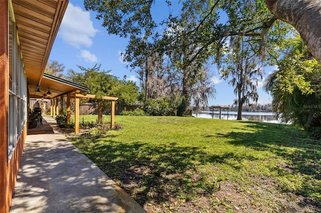 view of yard with a water view and fence